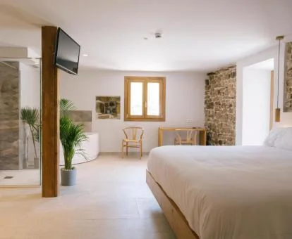 Una de las amplias habitaciones de categoría superior con bañera de hidromasaje privada cerca de la cama.