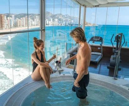 Pareja disfrutando del jacuzzi con espectaculares vistas del spa del hotel.