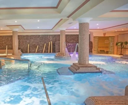 Piscina cubierta con elementos de hidroterapia del spa del hotel.