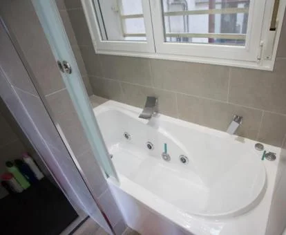 Baño con bañera de hidromasaje privada de este apartamento privado.