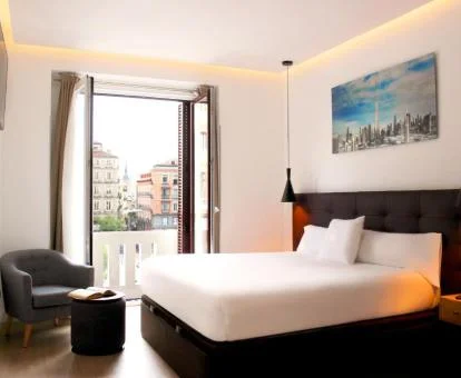 Una de las acogedoras habitaciones con balcón y vistas a la ciudad del hotel.