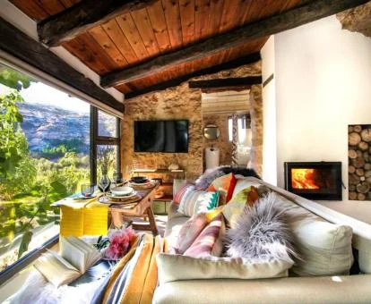 Precioso salón con vistas a la naturaleza de una de las suites de este alojamiento.