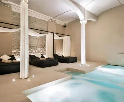 Zona de bienestar del hotel con piscina dinámica y cómodas camas.