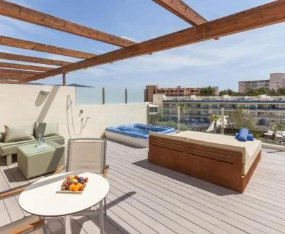 Espectacular terraza con mobiliario exterior y un gran jacuzzi privado del apartamento ático.