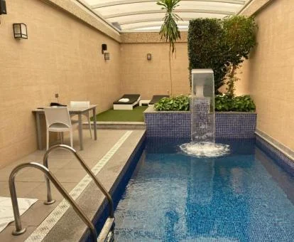 Preciosa piscina cubierta con cascada de una de las habitaciones de este hotel.