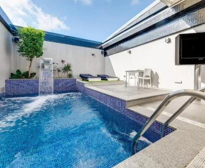Preciosa terraza con piscina privada con cascada, solarium y zona de estar de la Suite Superior.